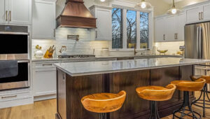 New Kitchen Island and Stools sitting around large island and view of oven, stove and sink