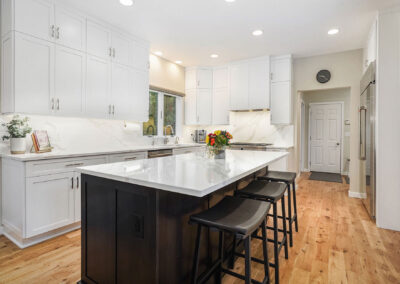 Updated Kitchen Design and Lighting with large Island and stool seating with bright cabinetry