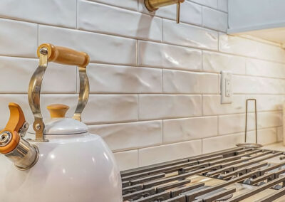 New Stovetop area in remodeled kitchen with white tile backsplash