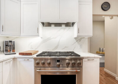 Improved Kitchen Stove and Layout with stainless steel oven and white cabinetry