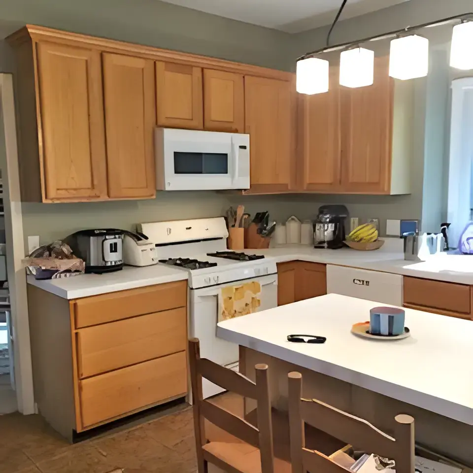Old kitchen cabinets and counters with island in foreground